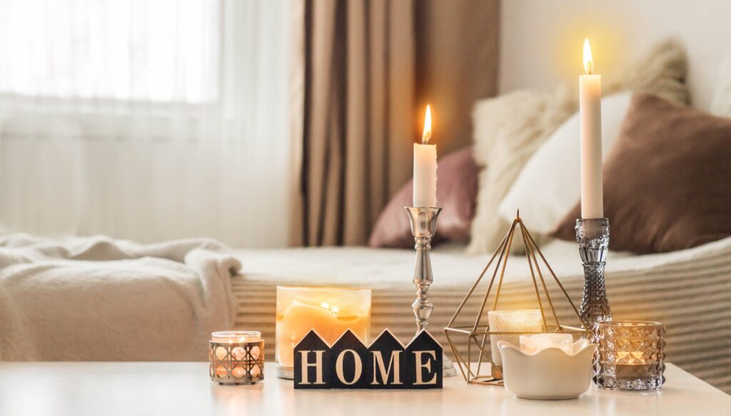 A lot of candles with candlesticks on the home background. Home and home decor. Candles flame