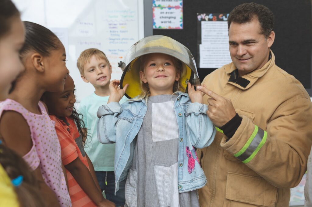 Firefighter teaching to school kids about fire security