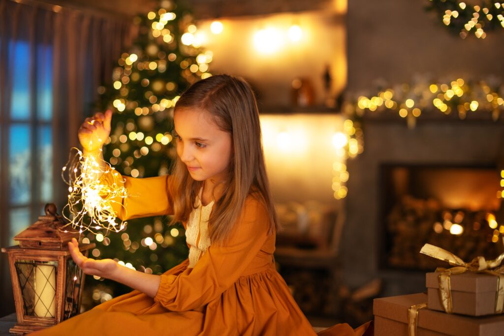 **Portrait of a blonde little girl in an elegant dress in a room with a Christmas tree